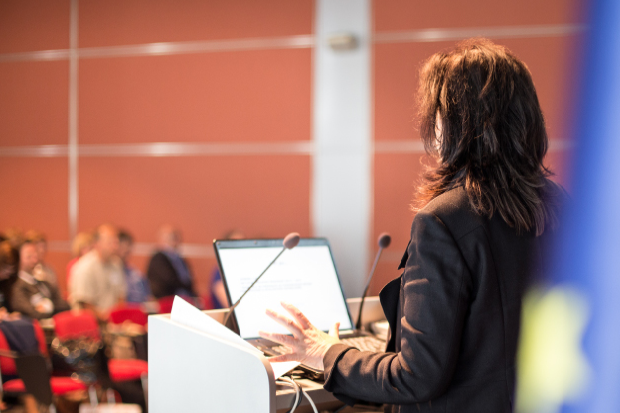 Woman at podium speaking to an audience