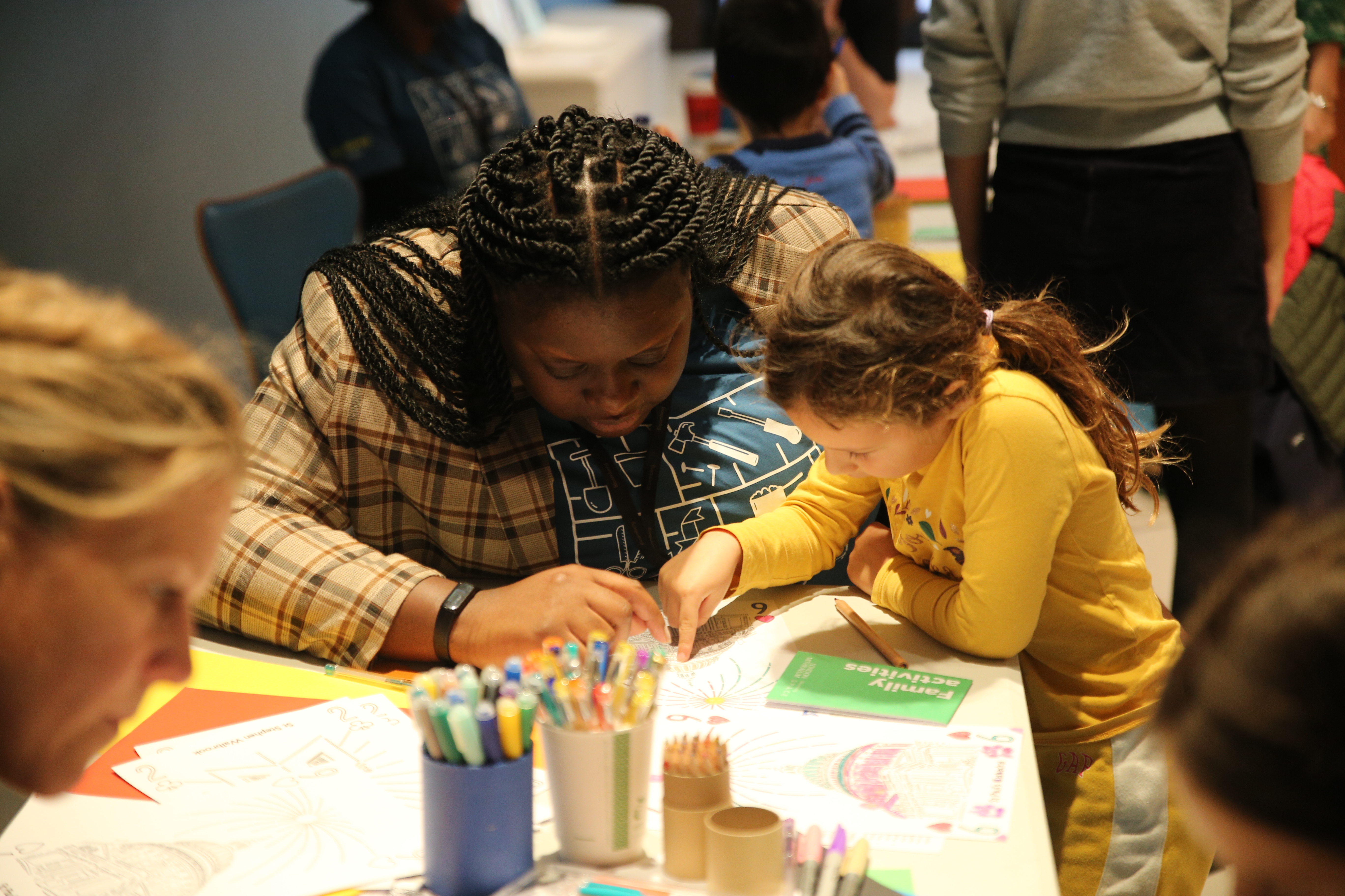 An adult helps a child with a crafting activity