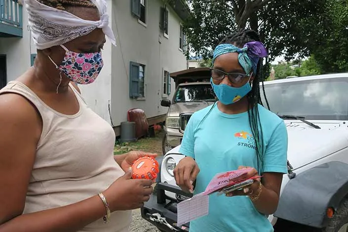 Two women on the island of St John discuss plans on notes they