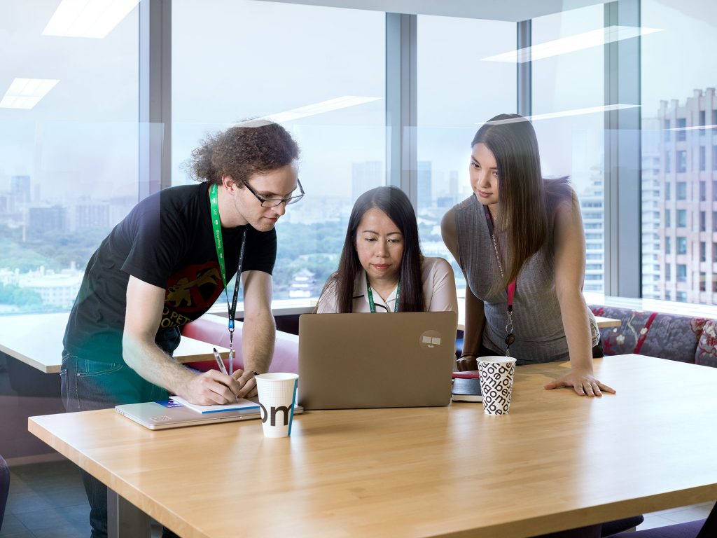 Department team huddled around laptop