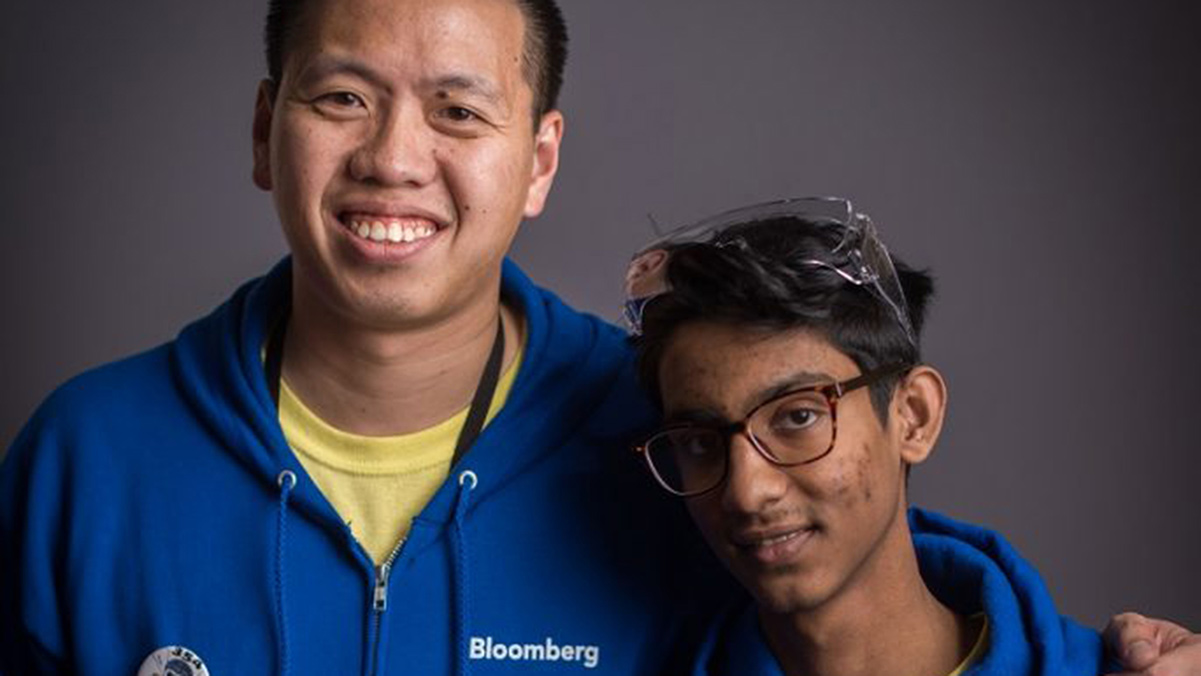 A Bloomberg volunteer and their mentee post for a photo at a FIRST event.