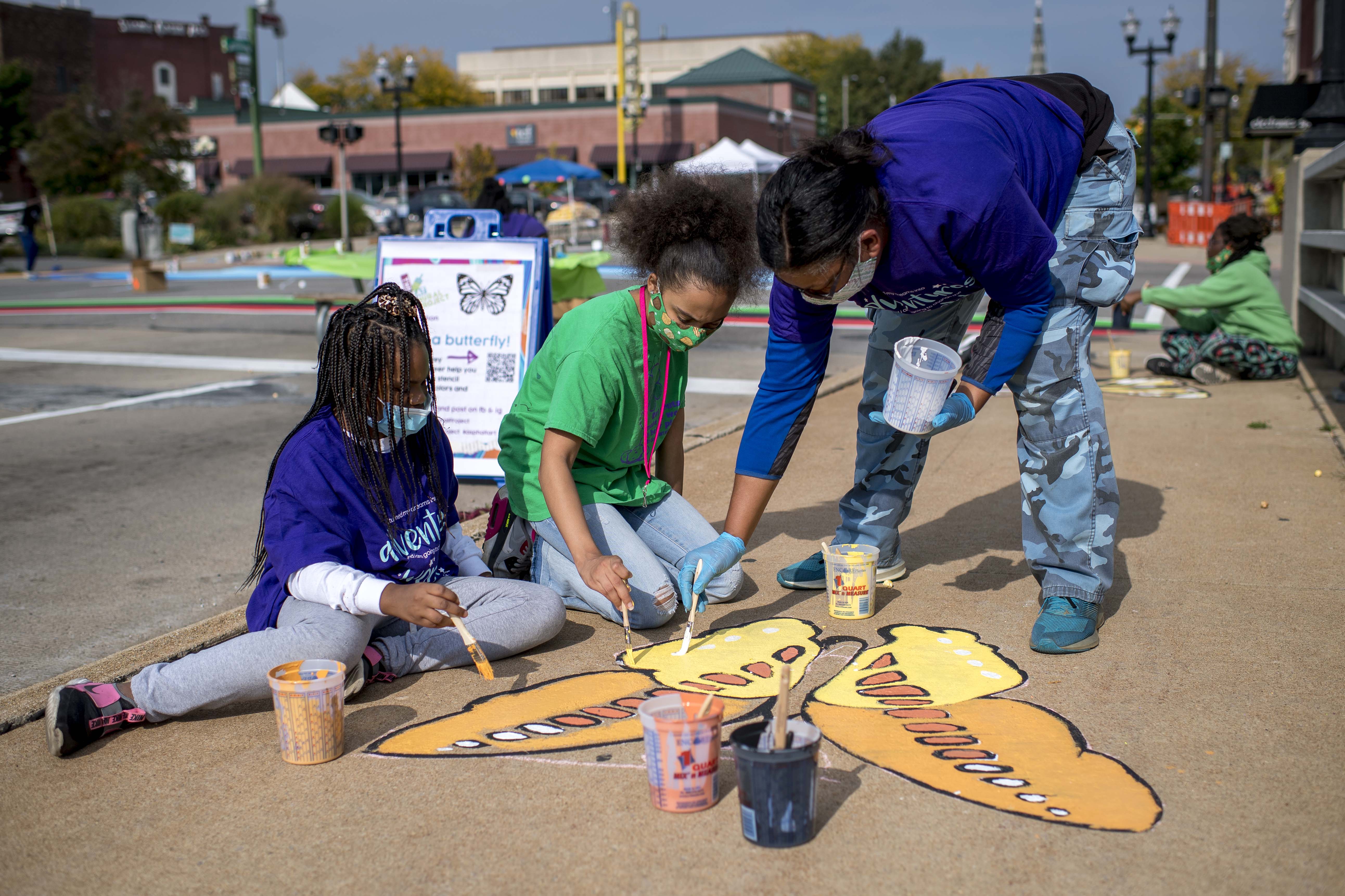 Painting butterflies along Court Street during the Great Mural Project