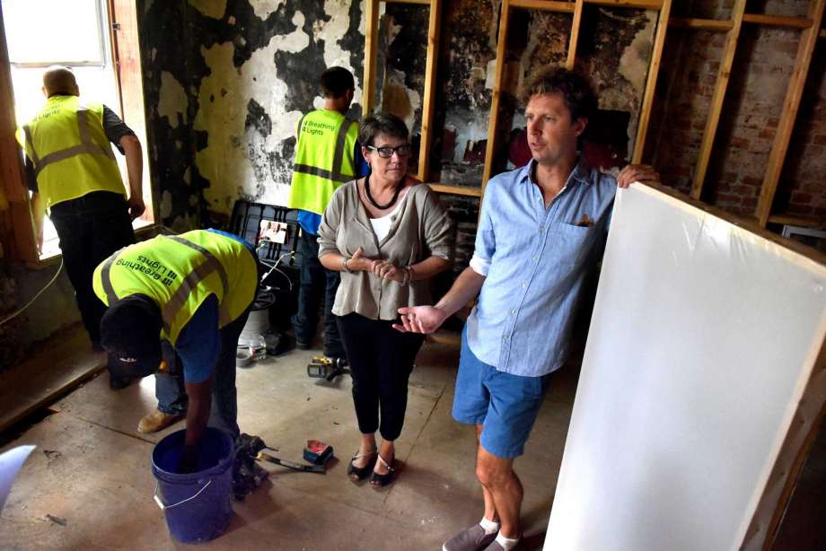 Lead architect Barbara Nelson, center, and lead artist Adam Frelin, right, talk about the installation of the Breathing Lights urban art project on Tuesday, Aug. 30, 2016 at 162 Clinton Ave. in Albany, N.Y. All Mighty General Contractors are installing the light panels. (Cindy Schultz / Times Union)