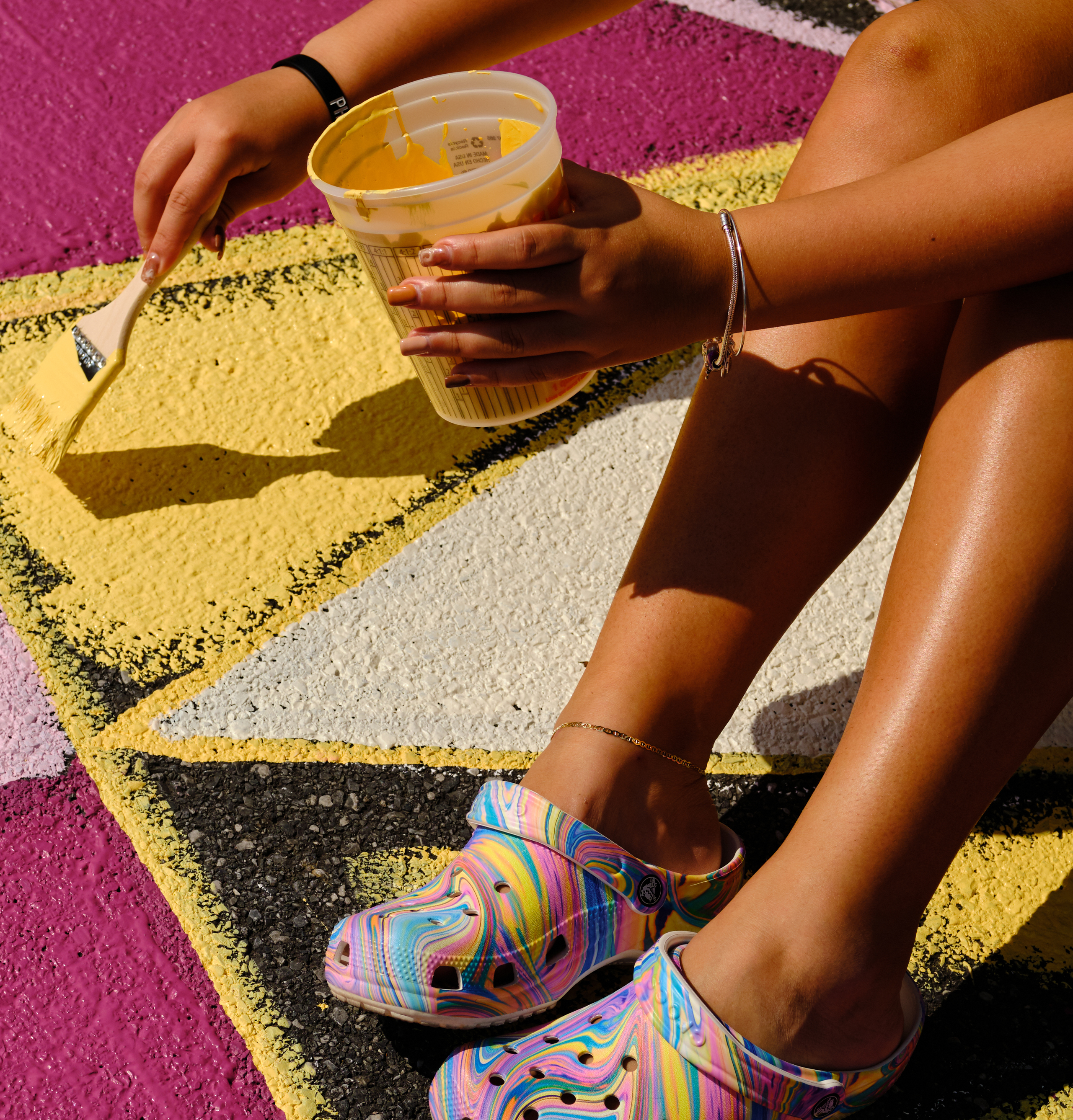 Local artists and citizens paint a mural on the stree