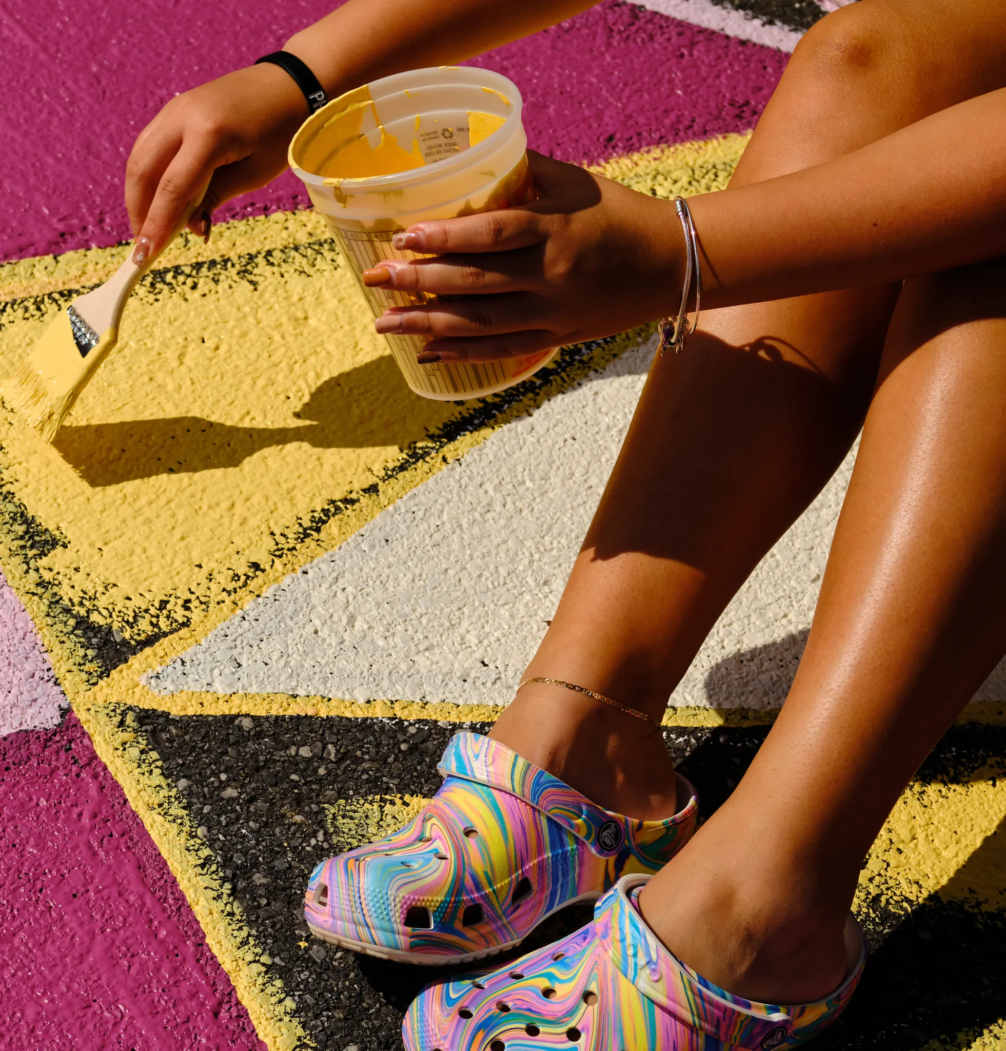 Local artists and citizens paint a mural on the stree