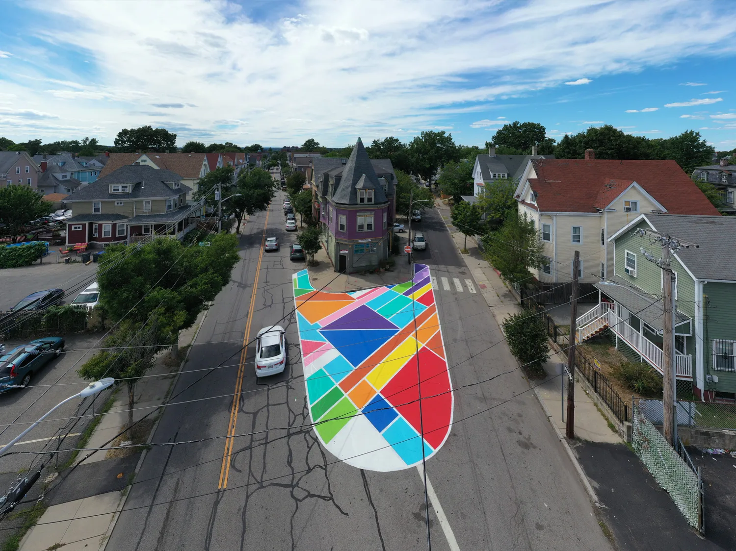 Aerial shot of colourful asphalt art in front of a building on the pavement