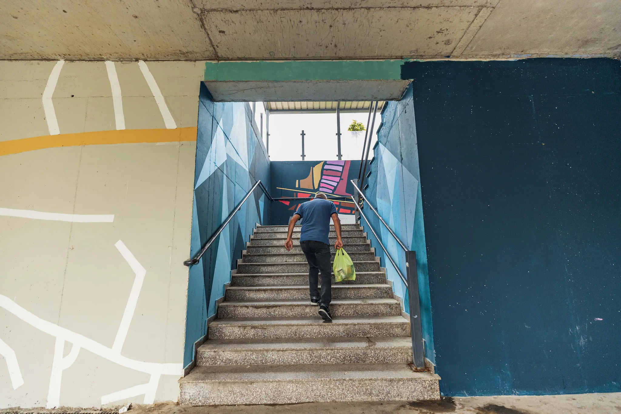 A man climbing staris of the Ferizaj, Kosovo underpass