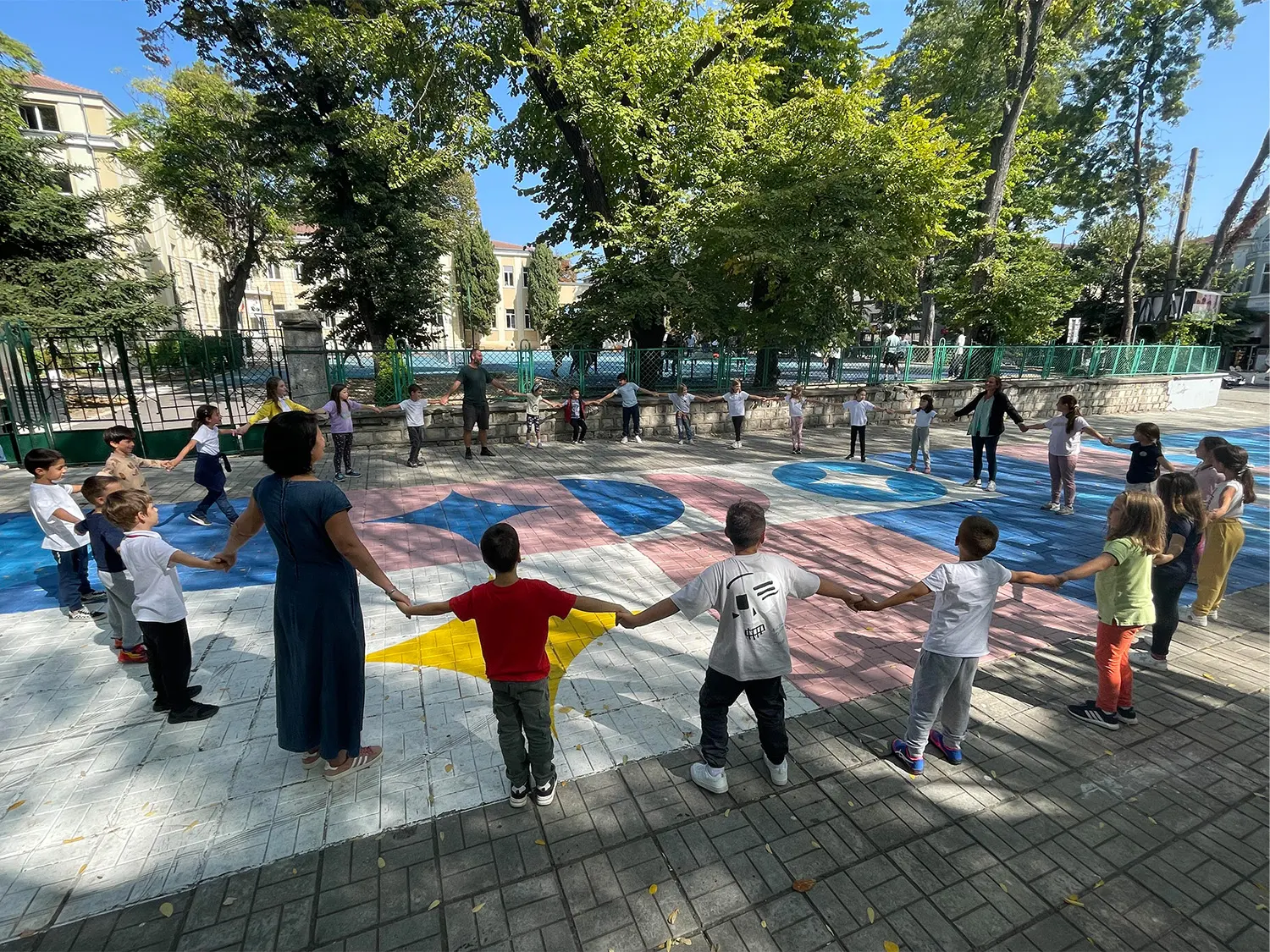 Community people holding hands and circling around in Varna park