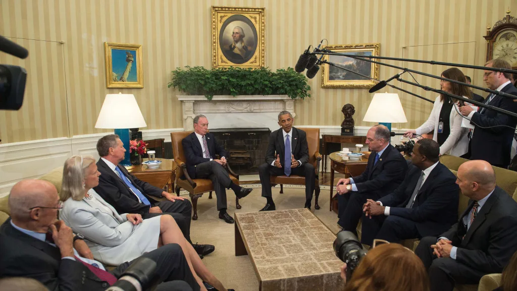 Photo of Mike discussing global trade deals with Obama and others.