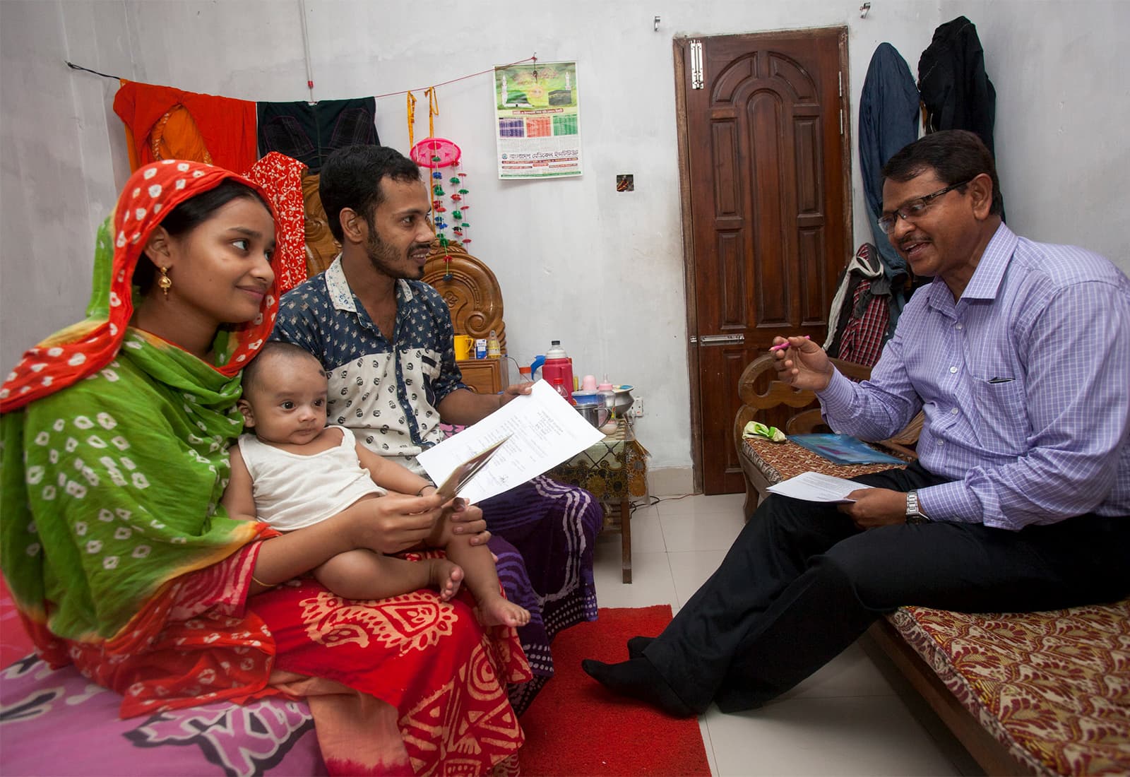 Bangladeshi family participates in Data for Health program, recording birth and death information with local officials to find out how best to allocate resources and find solutions to improve and save lives.