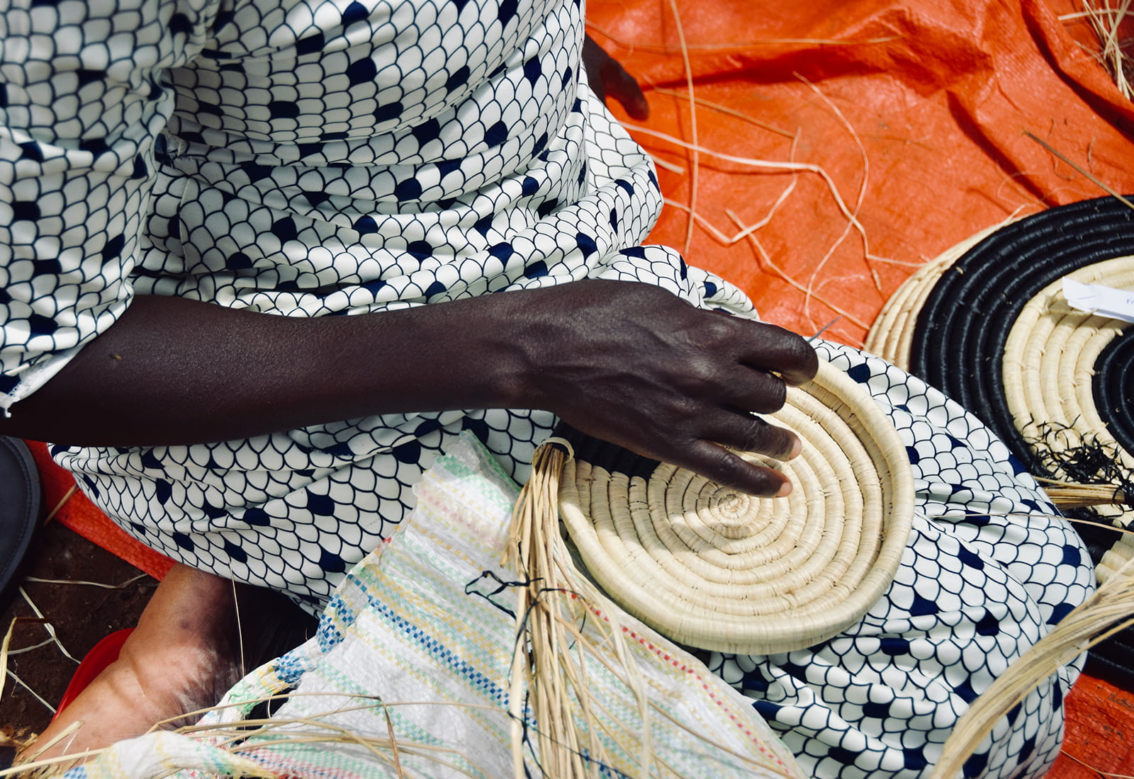 The beginning stages of a utensil holder on the lap of an artisan weaver in Uganda. Photo credit: Nest