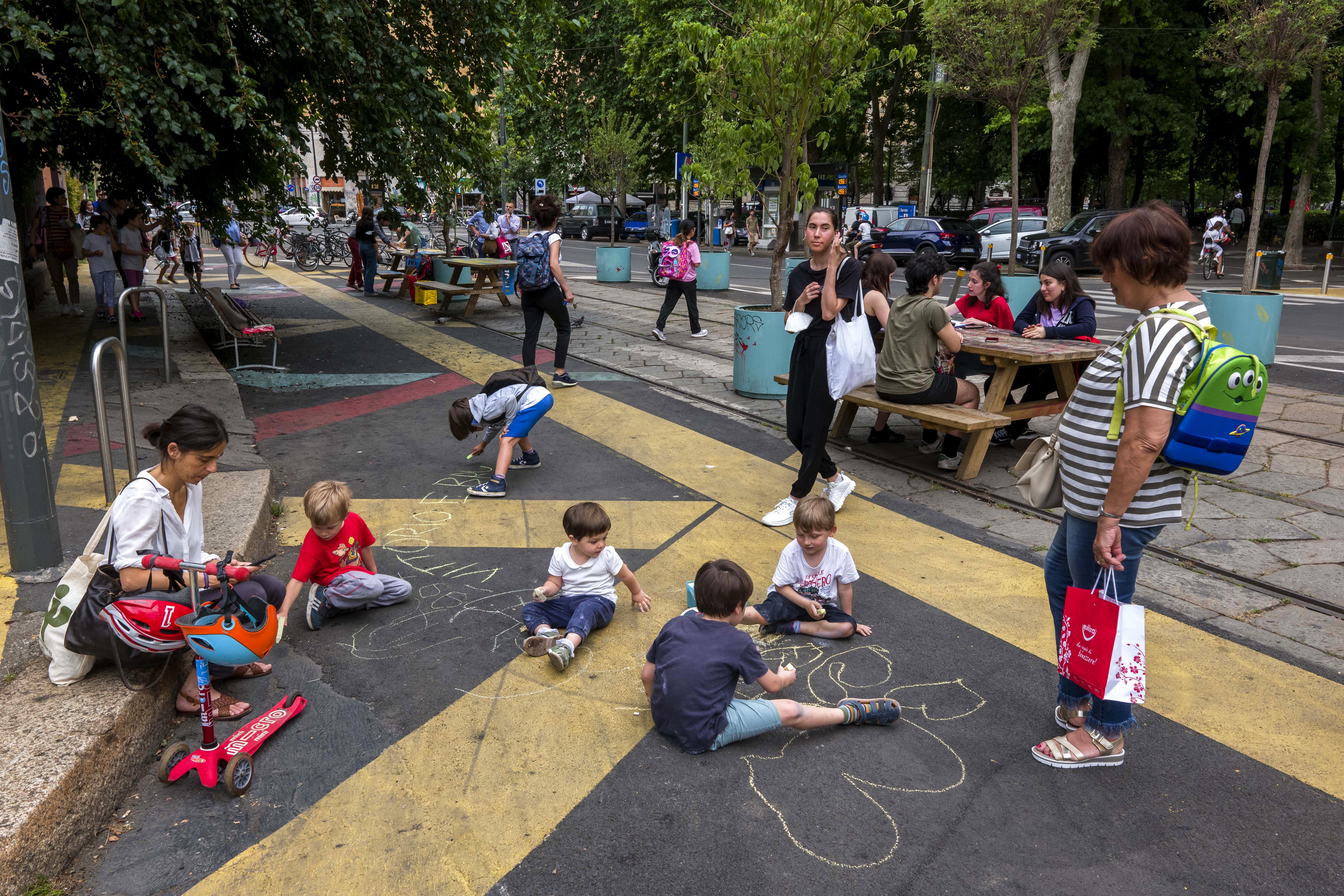 Dynamic public plazas around the city in Milan where kids are playing with chalk