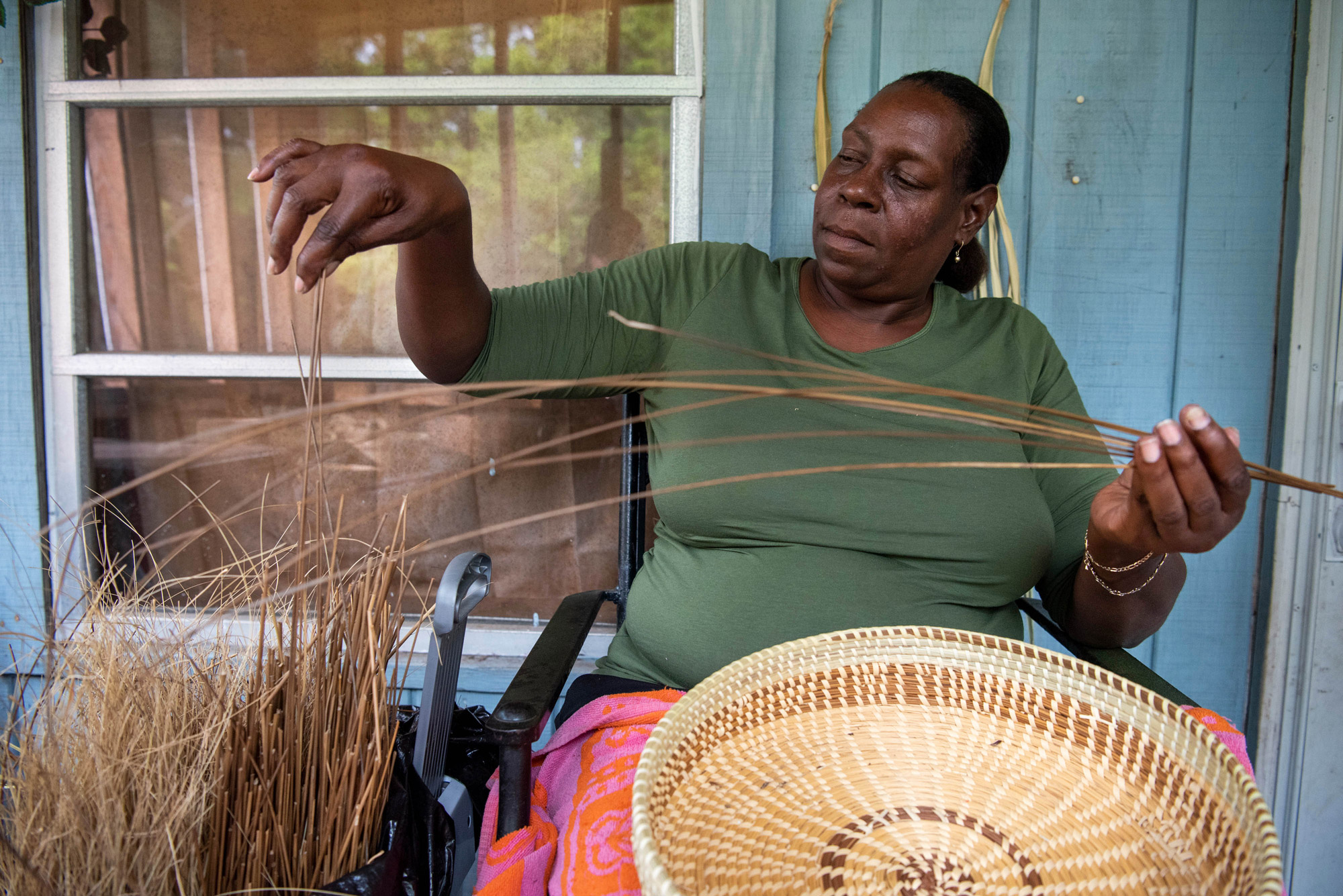 Women sweetgrass weavers making a bowl out of grass