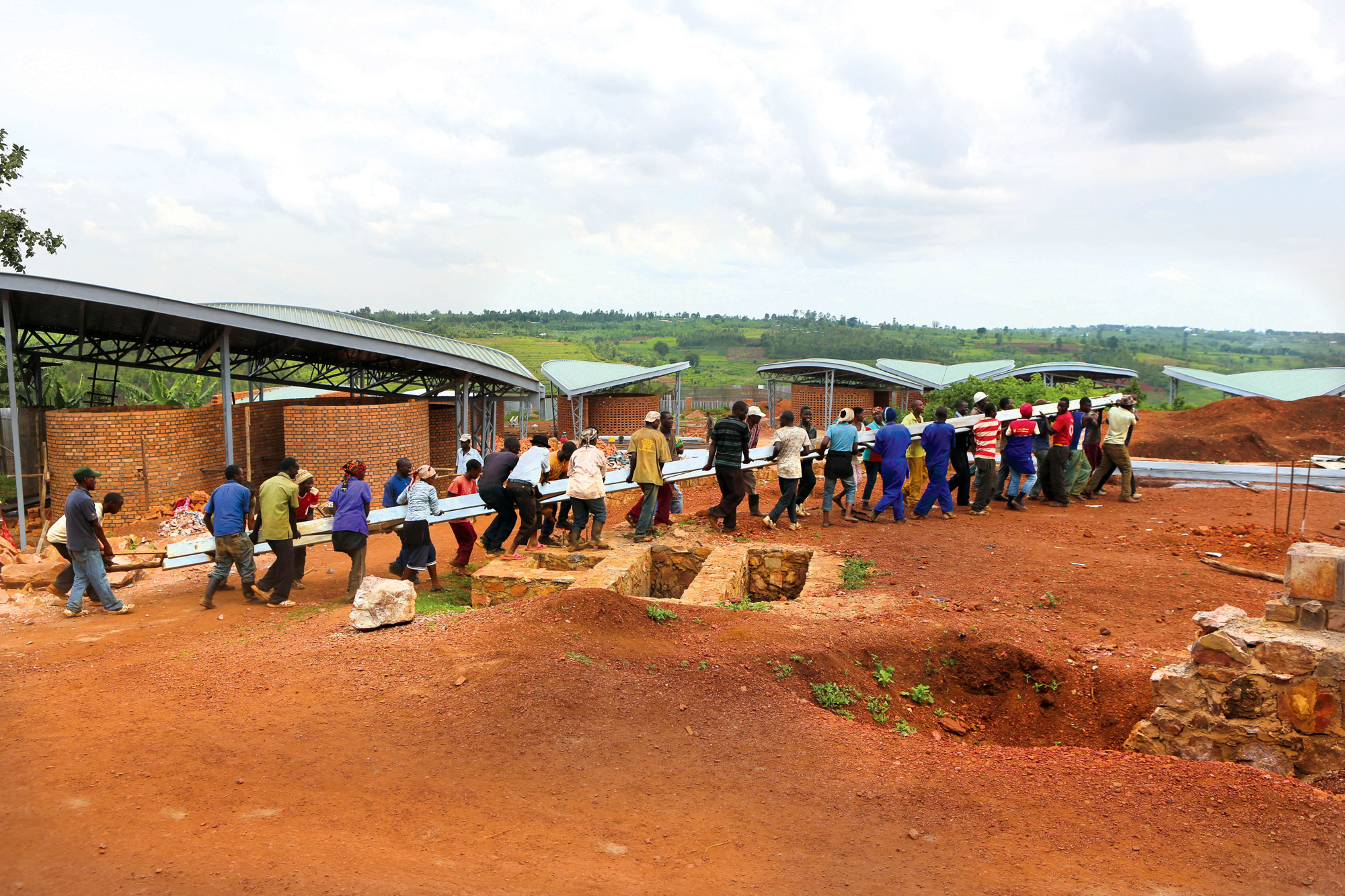 Team walking with the beam on the build of six classrooms, Rwanda Construction