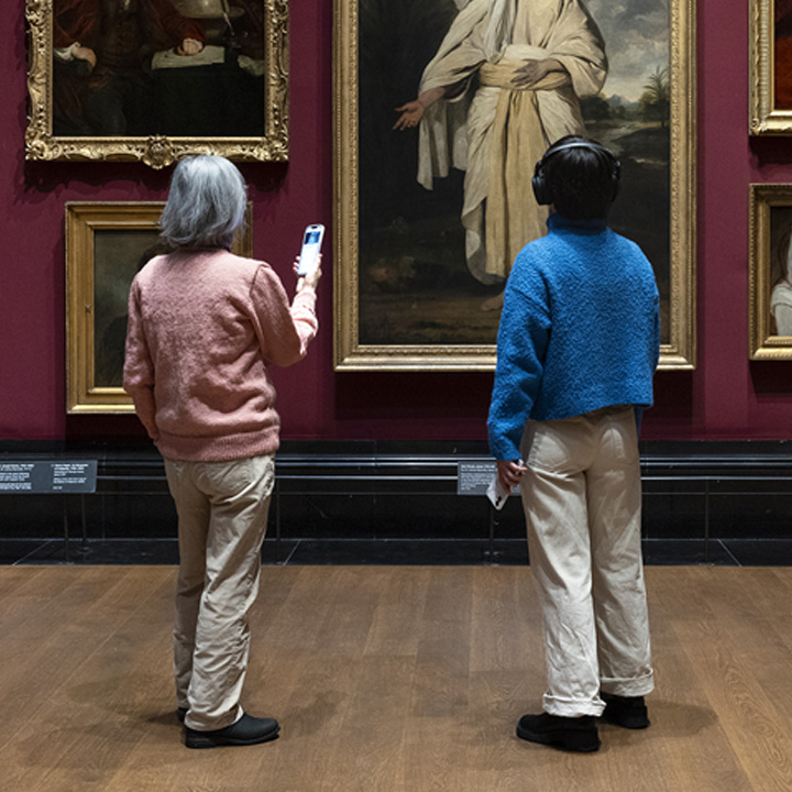 Two women exploring painting in an art museum