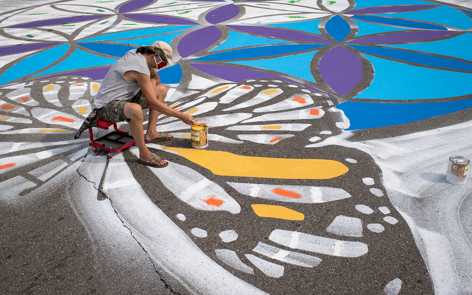 A man paints at the intersection of Ezra Rust Avenue and Fordney Street during the Great Mural Project Asphalt Mural Paint-A-Thon on Sept. 26, 2020 in Saginaw, Michigan.