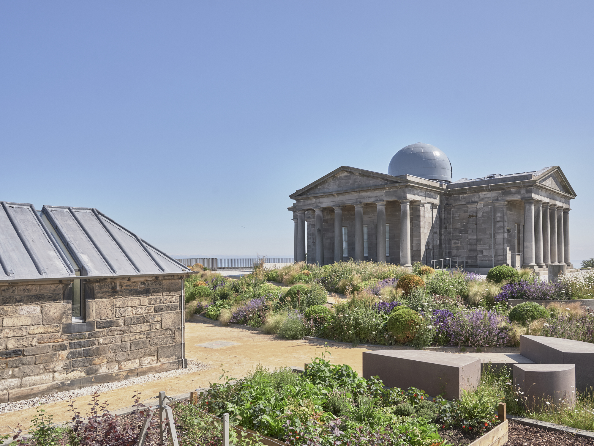 Exterior of Collective, City Obeservatory. A Greek-style building with dome and columns set against a blue sky background.