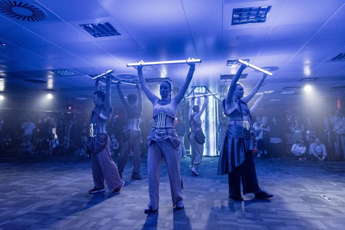 Performance at Hidden Door Festival. Performers in futuristic costume holding strip lights above their heads.
