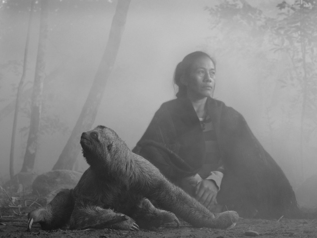 Bolivian woman sitting next to rescued sloth