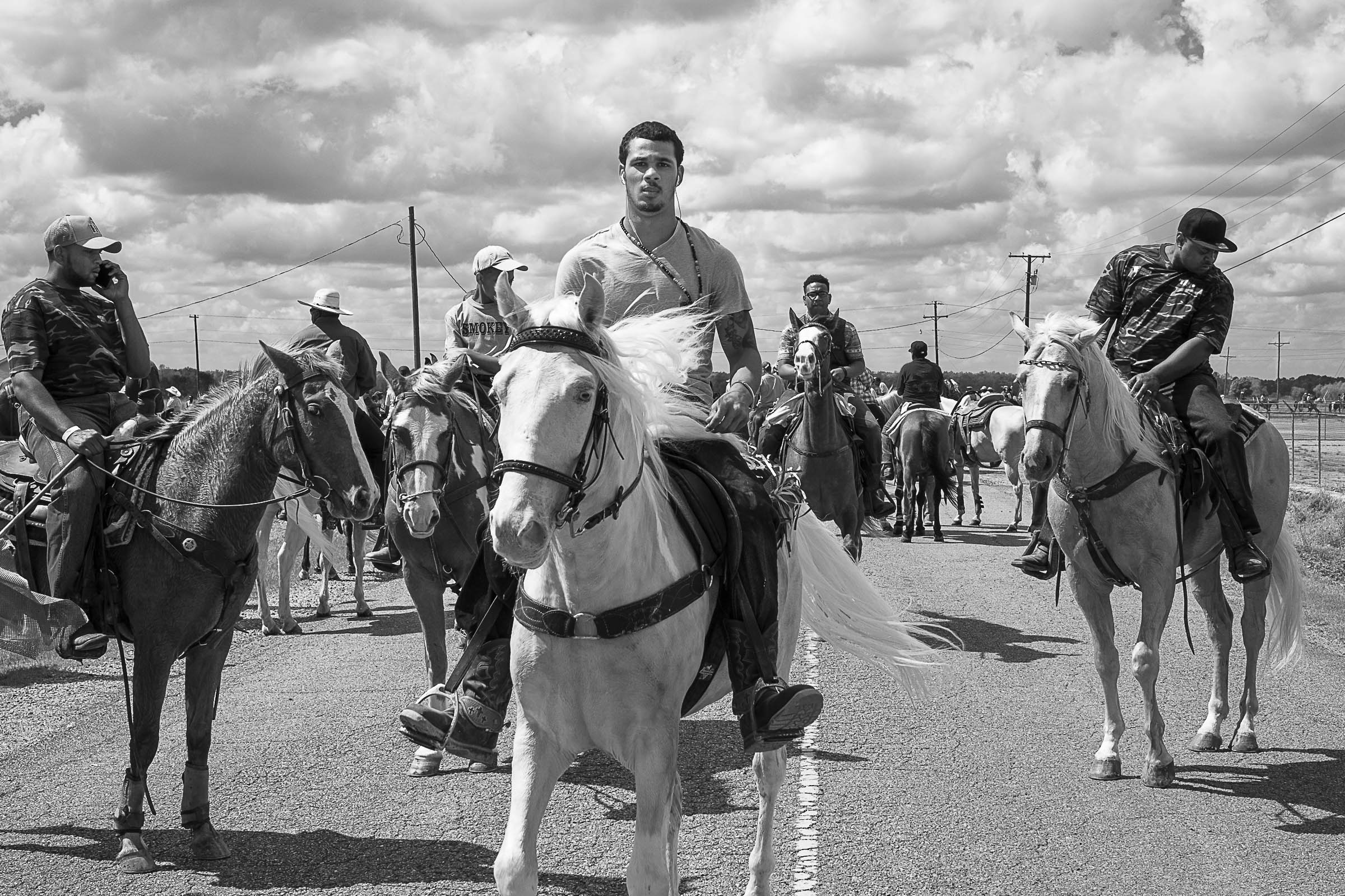 Black and white photo of a Black trail-riding club, on horseback with a cloudy sky behind them.