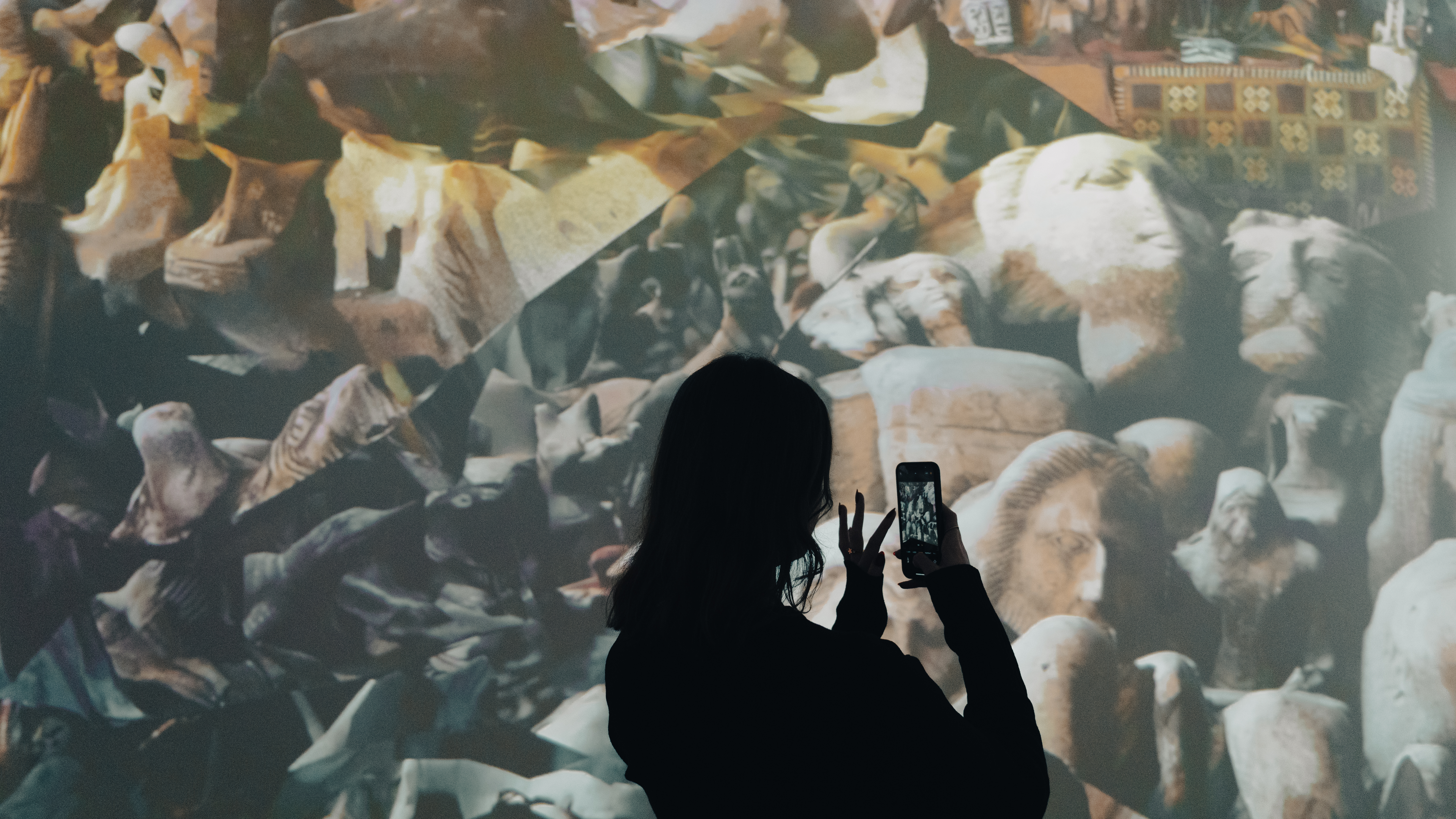 A young woman filming the immersive artwork around her