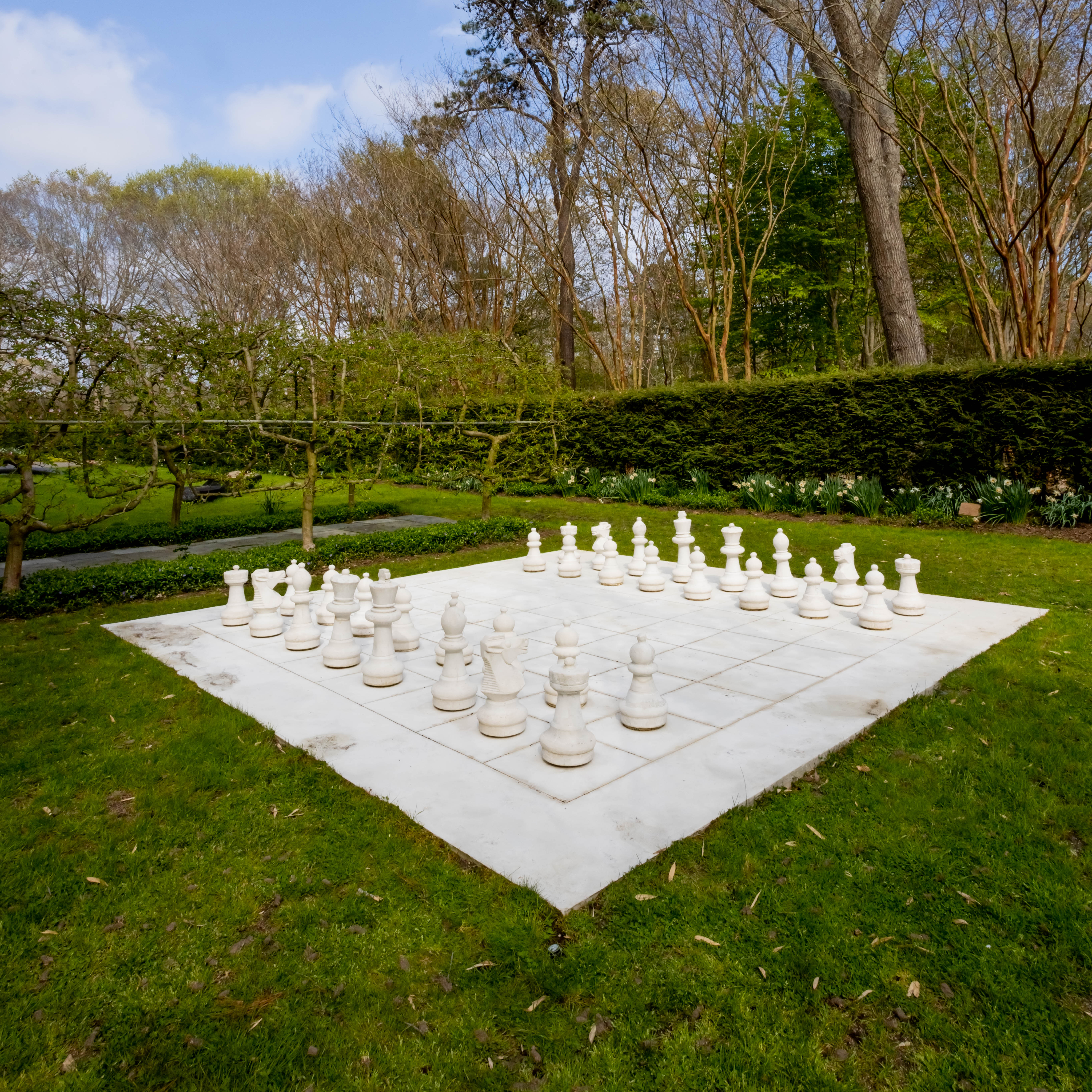 monumental, all-white chess set in garden