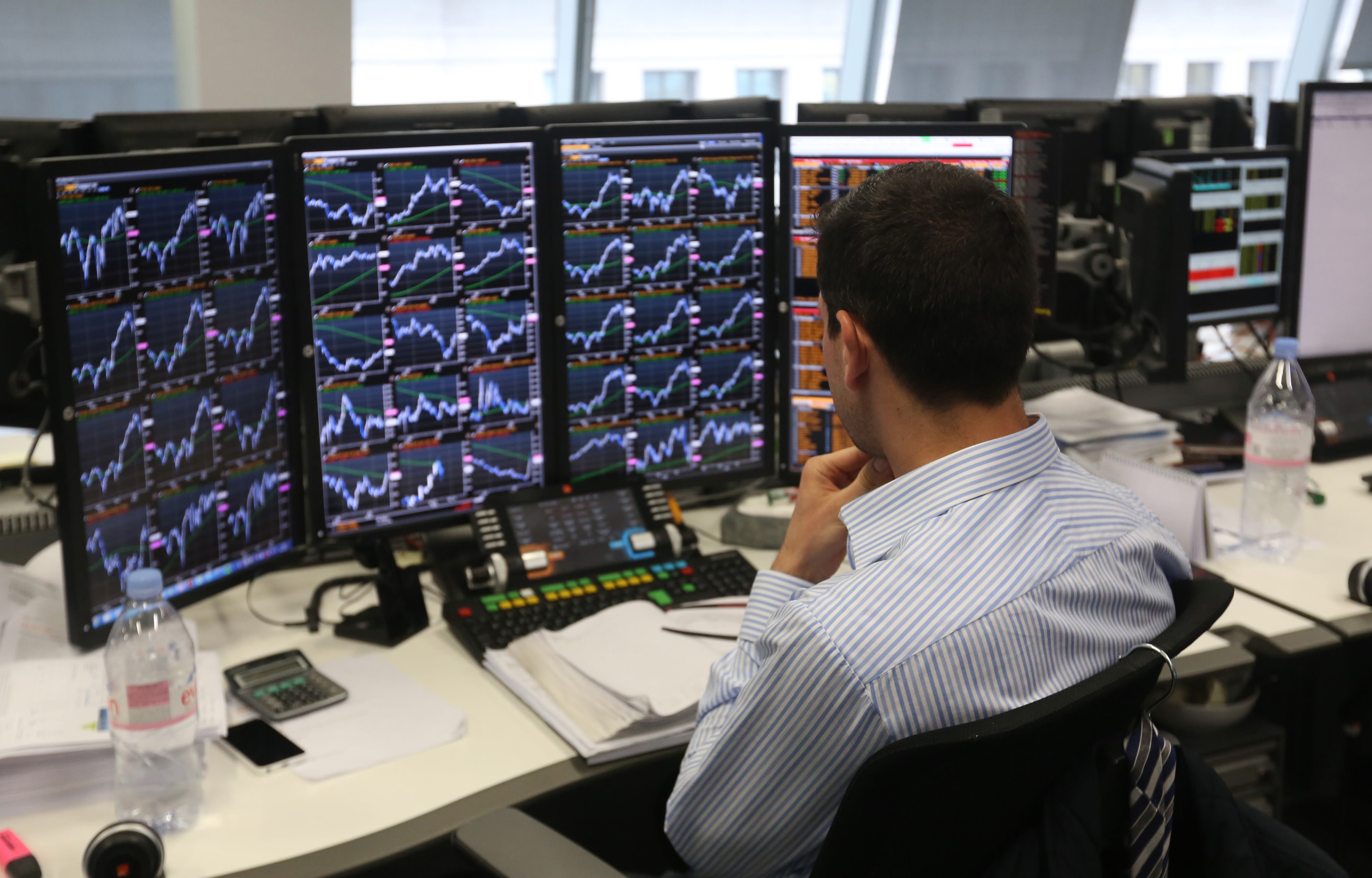 Торговля на бирже. Человек наблюдает много мониторов. Форекс трейдер. Трейдер за компьютером. Торговля на бирже.