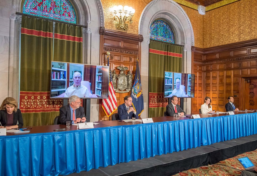 New York Governor Andrew Cuomo announces the state's contact tracing pilot program with support from Mike Bloomberg and Bloomberg Philanthropies. Cuomo sits with members of his administration during a press conference with Mike Bloomberg joining in via video conference call.