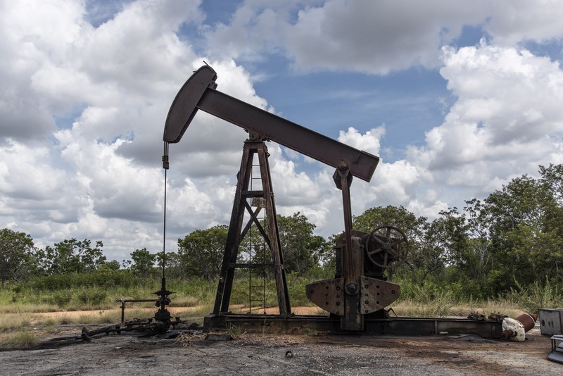 A pump jack stands near an oil spill at a facility in Venezuela.