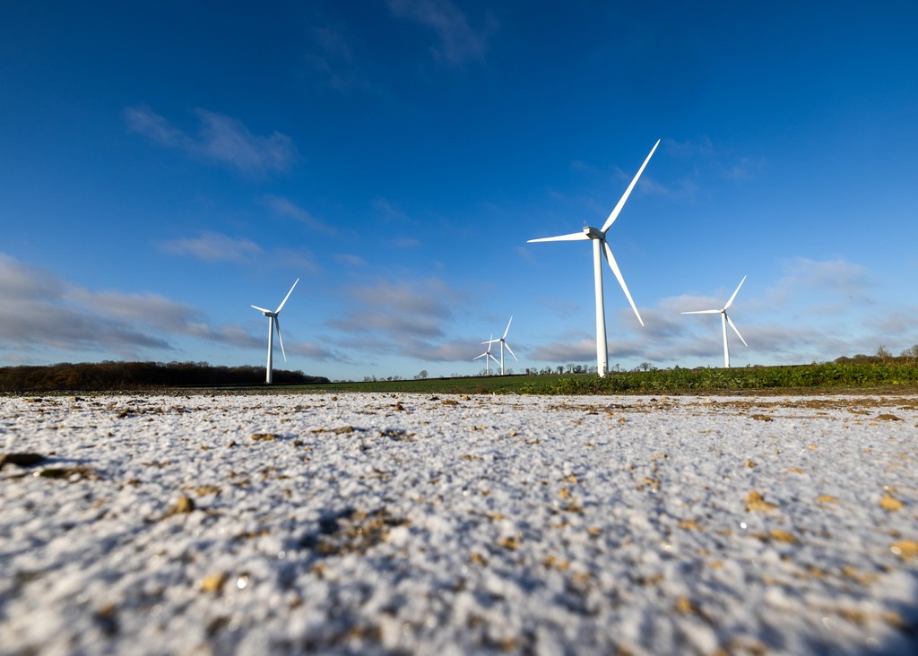 Wind turbines in a snow covered field.