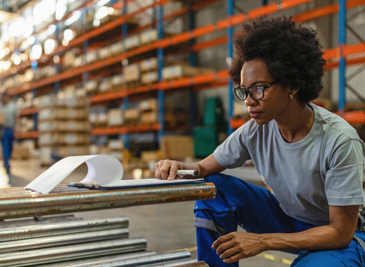 Person working and checking inventory details on a clipboard