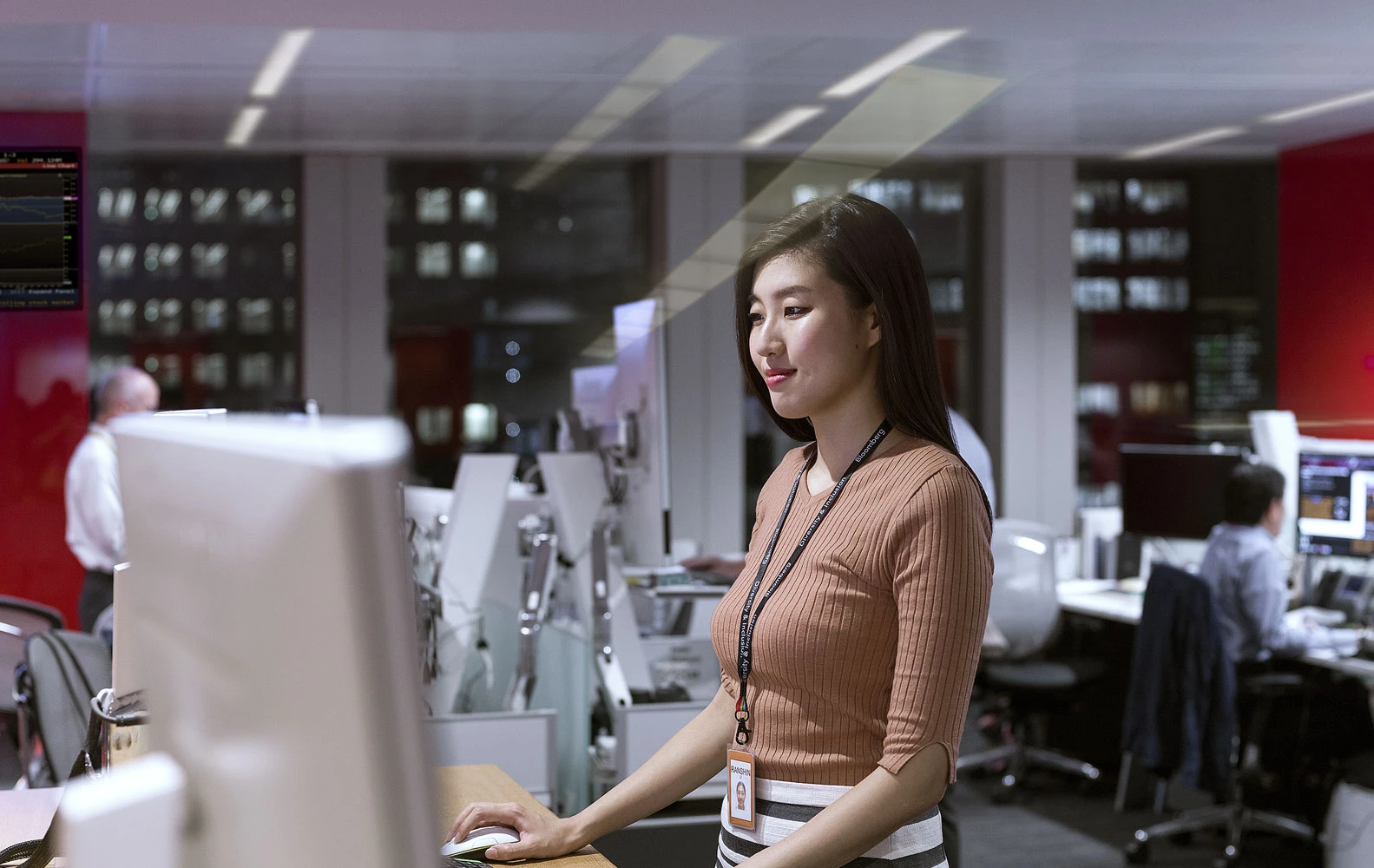 employee standing at desk computer