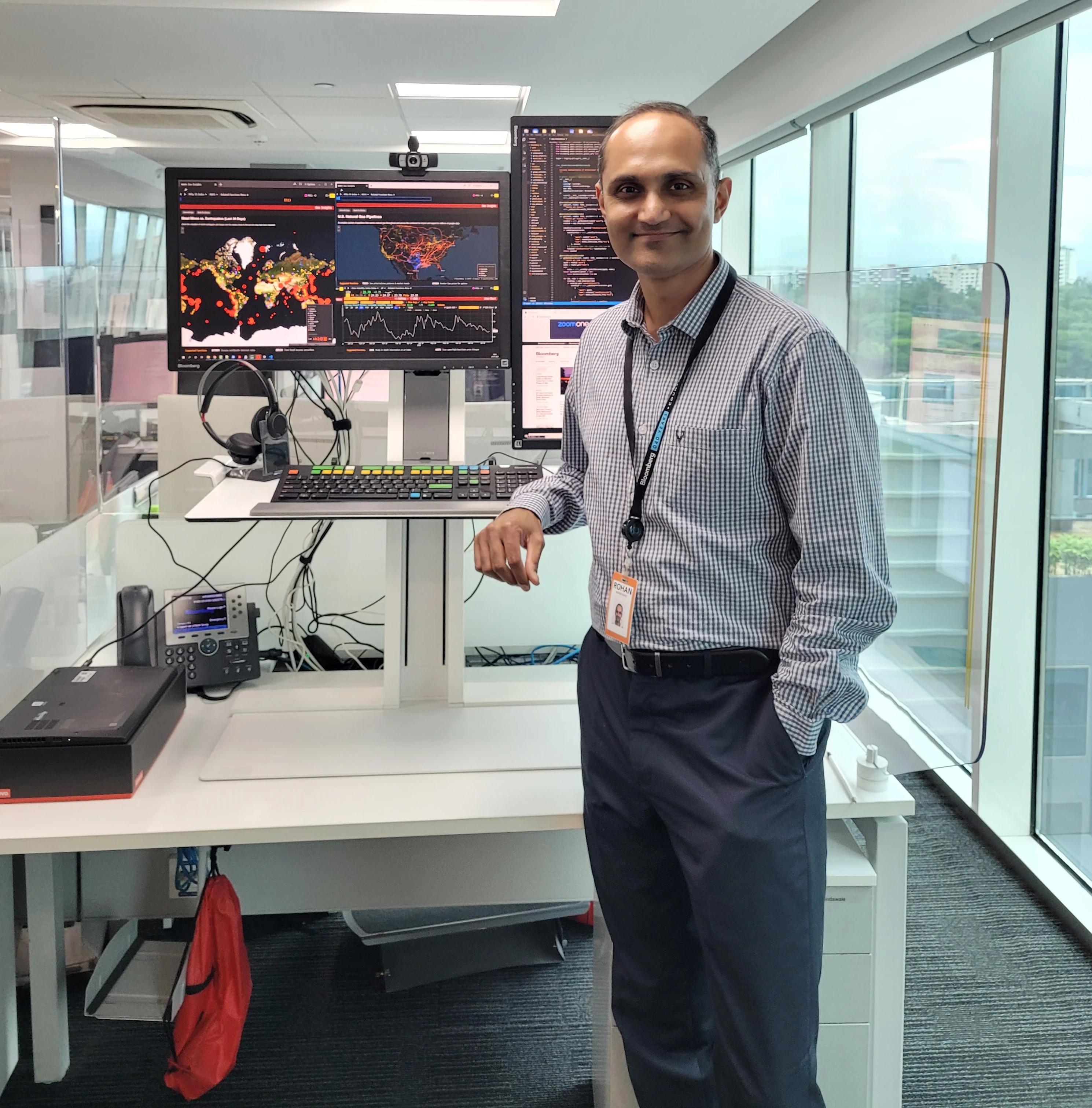 Rohan Bhindwale standing in front of his desk and computer in the Pune office.