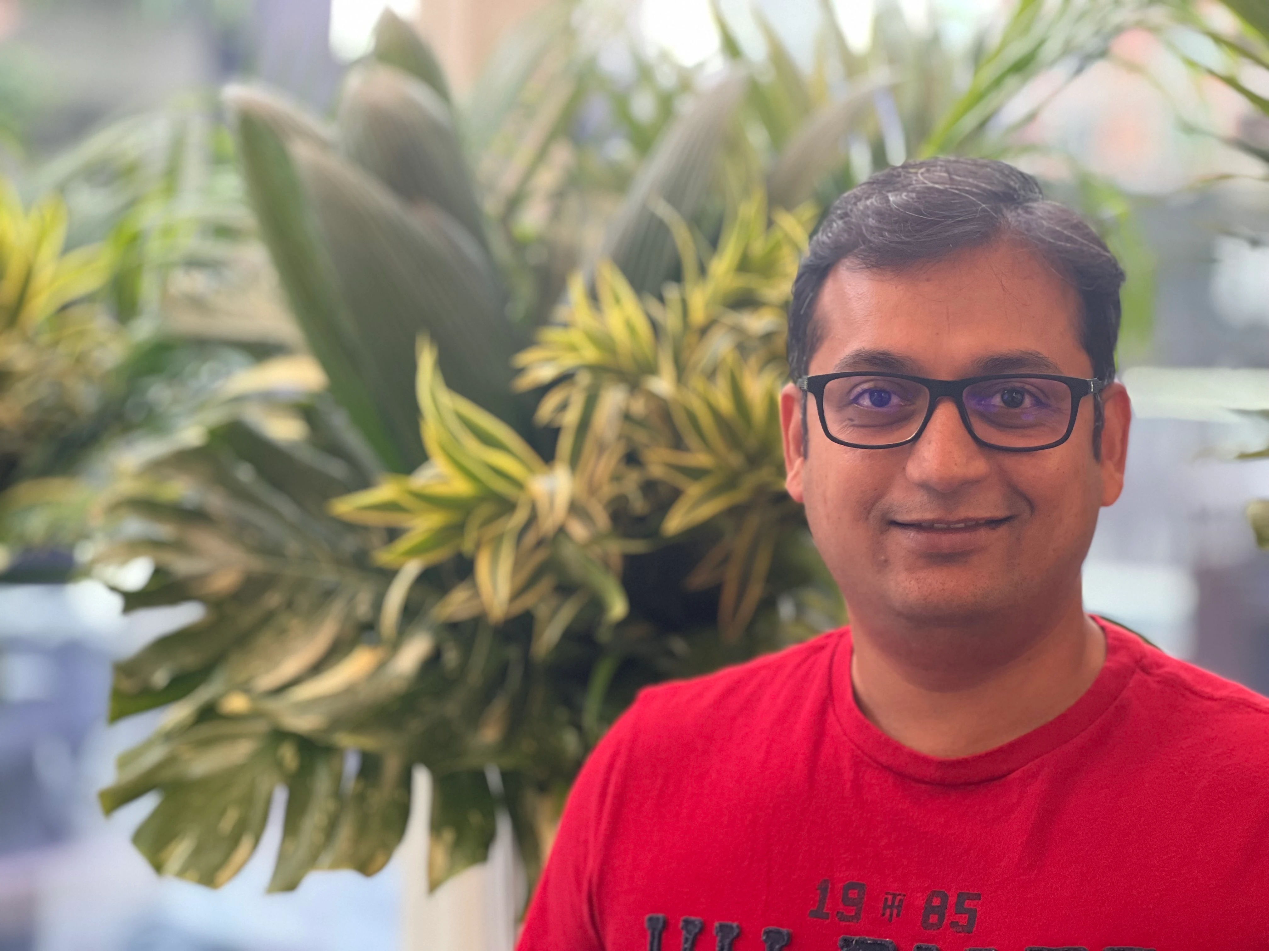 Sandip Gaikwad standing in front of some greenery.