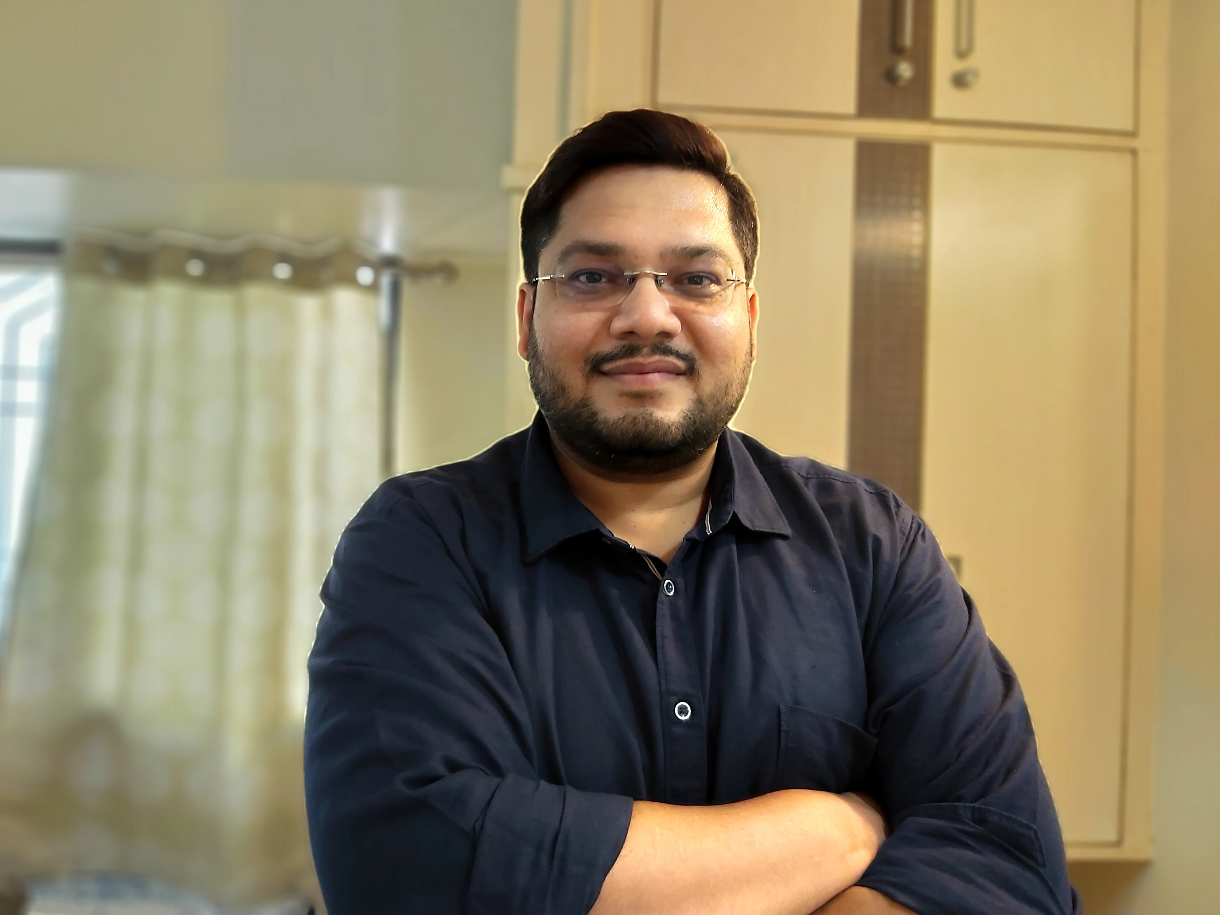 Sarang Chandaikar standing at home, with his arms crossed.
