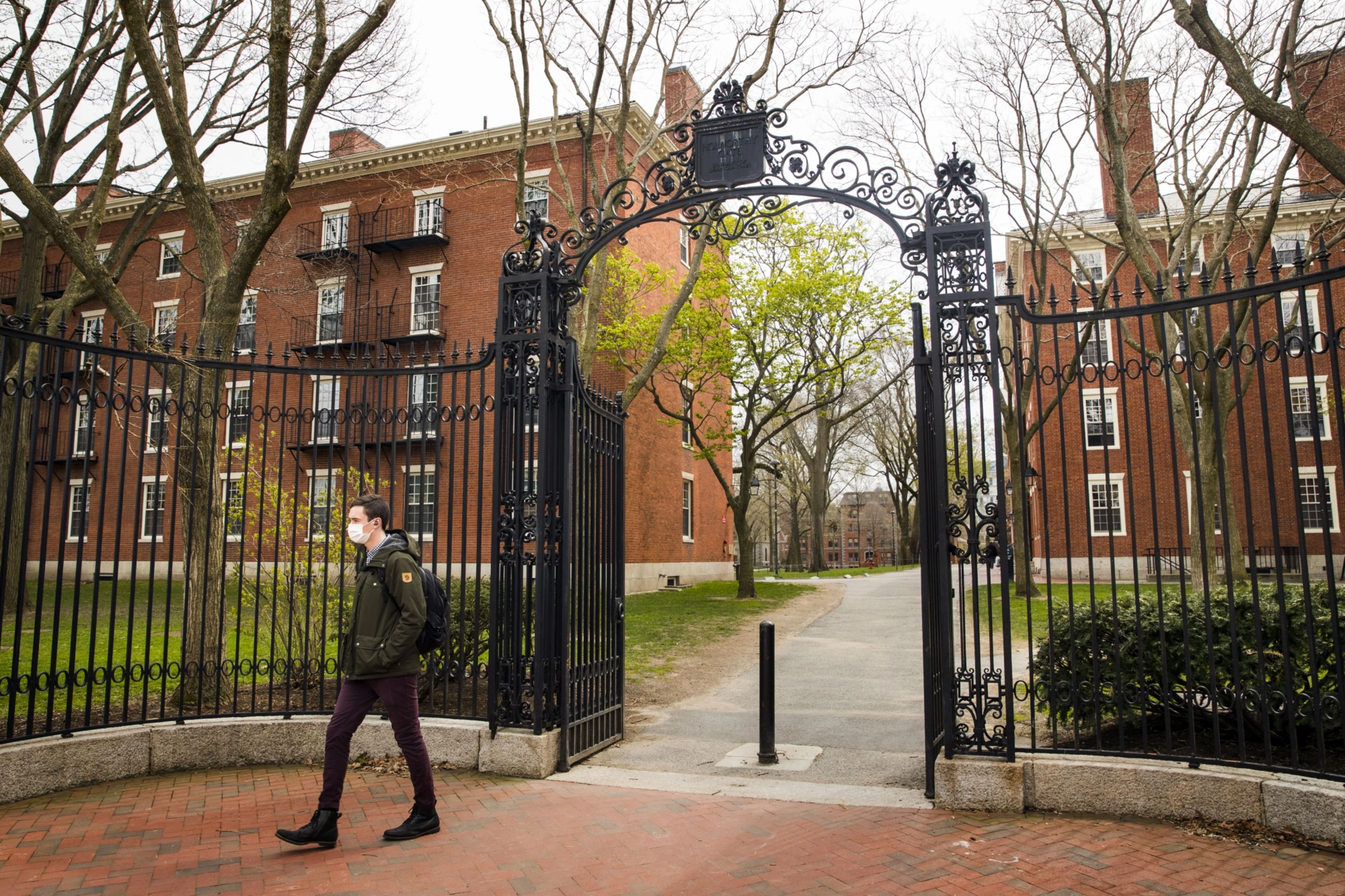 A pedestrian wearing a protective mask exits Harvard