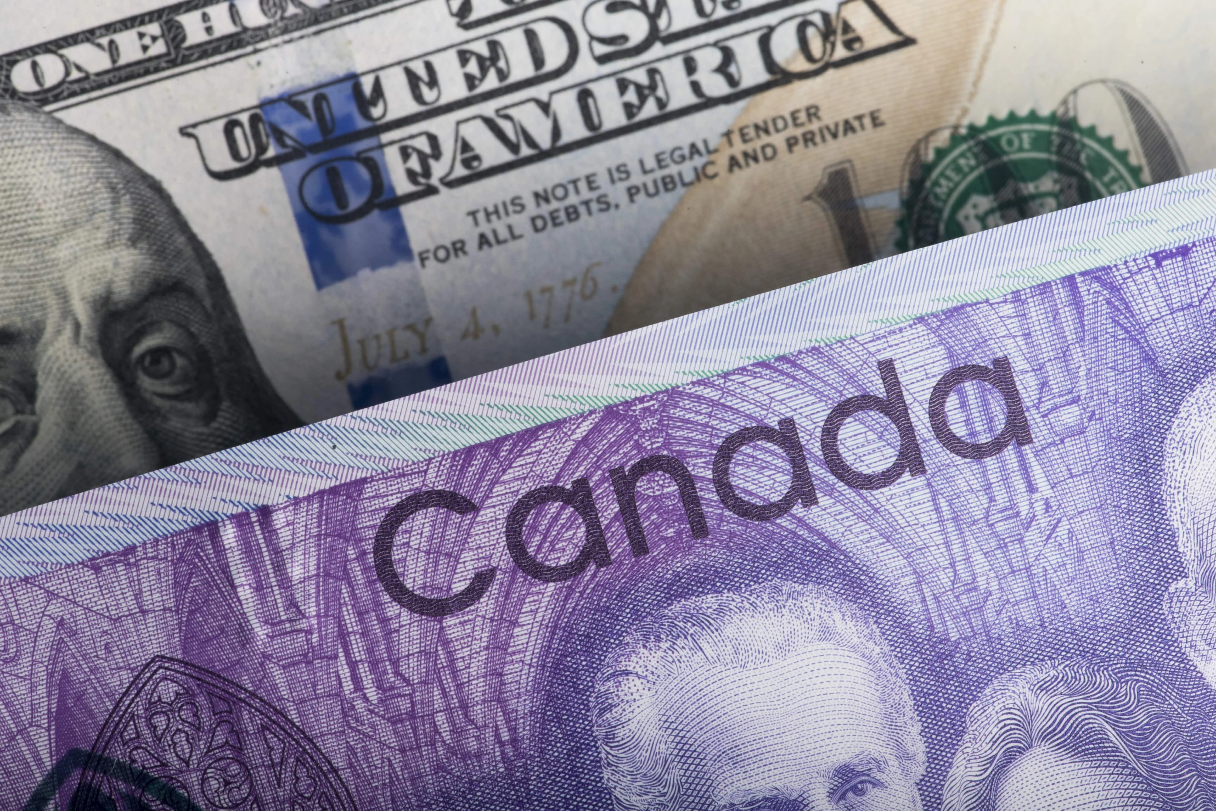 A U.S. one hundred dollar banknote and a Canadian ten dollar banknote