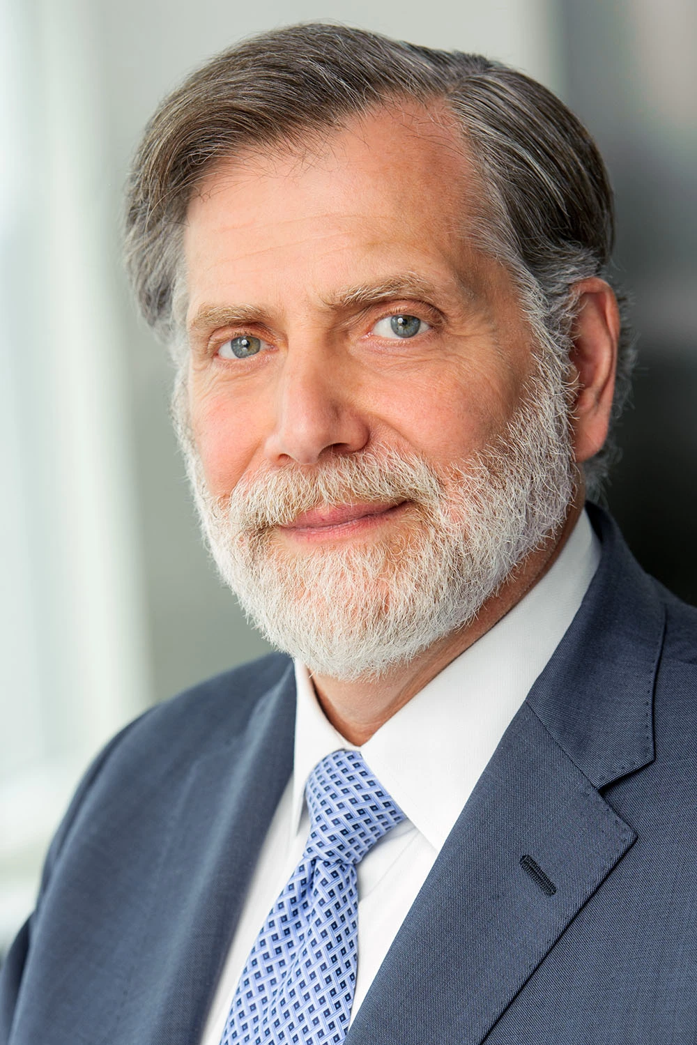 Tom-Secunda-headshot Tom Secunda poses for a headshot. He is a white male with a beard and he's wearing a navy suit with a blue tie and white shirt.