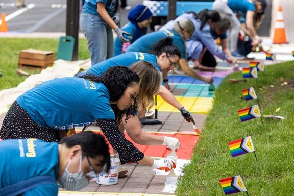 Pride flag painted on sidewalk of Bloomberg campus to celebrate Pride month and highlight the importance of inclusivity and allyship with the community
