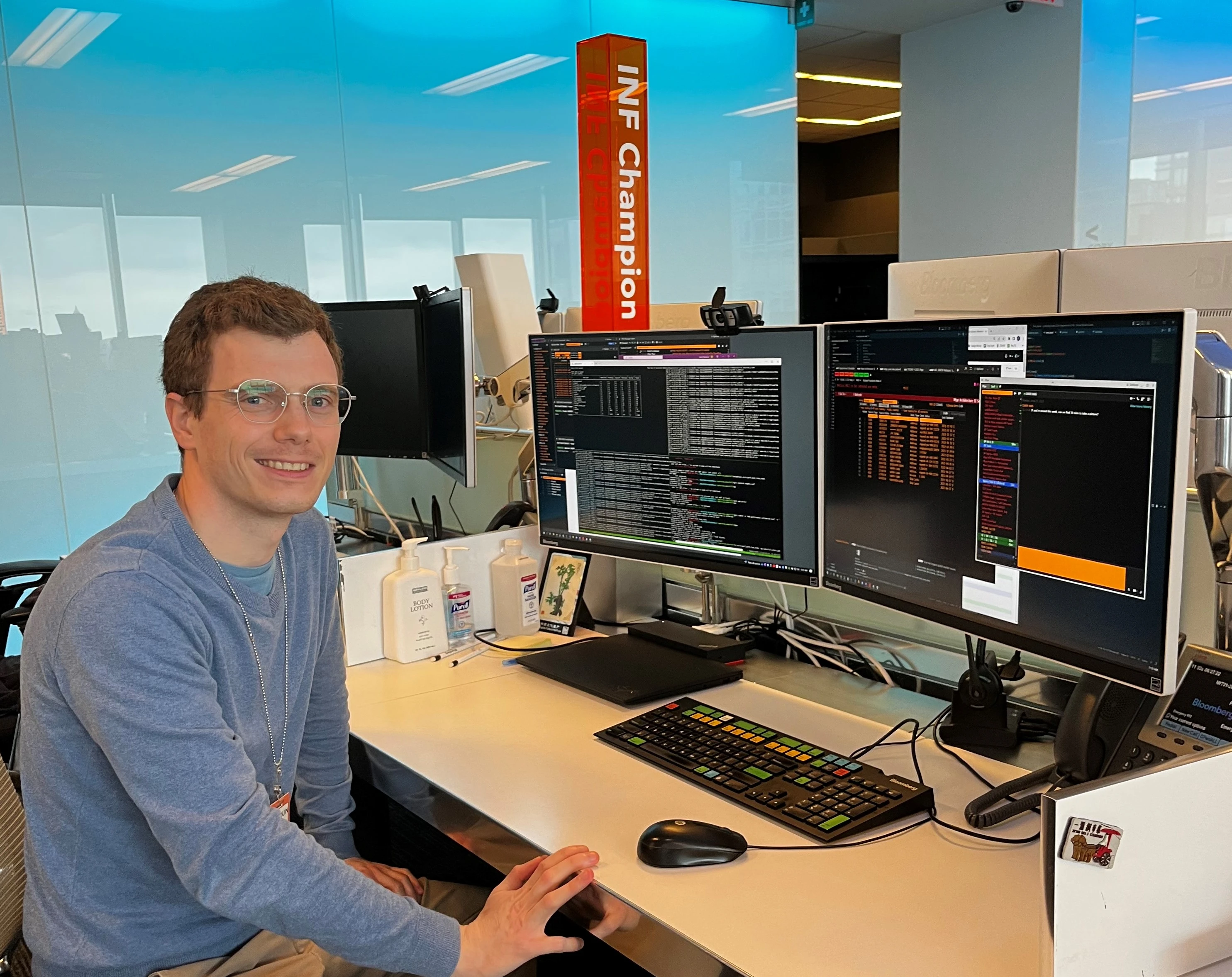 Baudouin Giard seated in front of his computer screens at his desk in the Bloomberg office