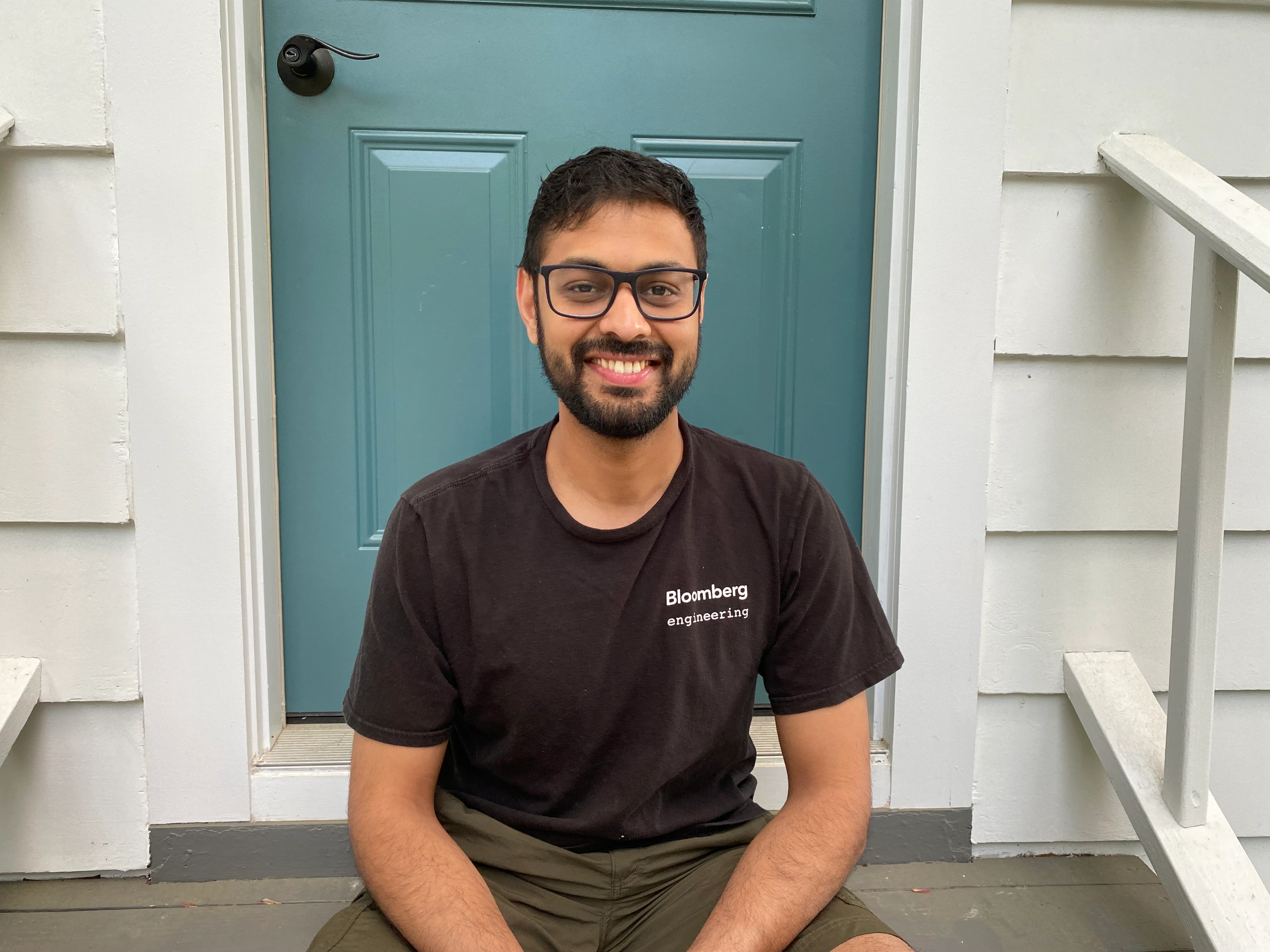 IMG_6275-select Rishab Gupta sitting on the steps outside a blue door