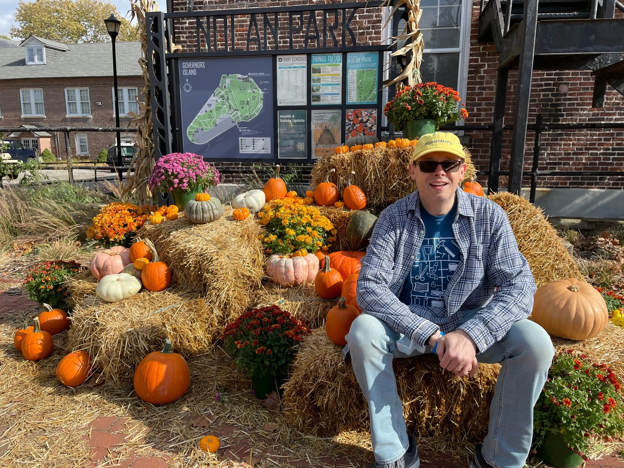 Sean_Matthiesen_Photo Sean Matthiesen sitting outdoors on bales of hay in the fall