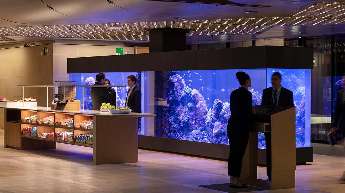 Bloomberg-London-office-prominently-features-diverse-fish-ecosystems-something-common-in-any-Bloomberg-office-around-the-world Two giant, dark-blue-glowing fish tanks fill the backdrop of the Bloomberg London building's employee pantry lounge.
